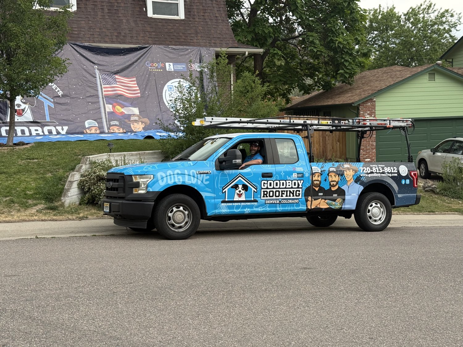 A GoodBoy Roofing project — home with the company truck and banner in Denver